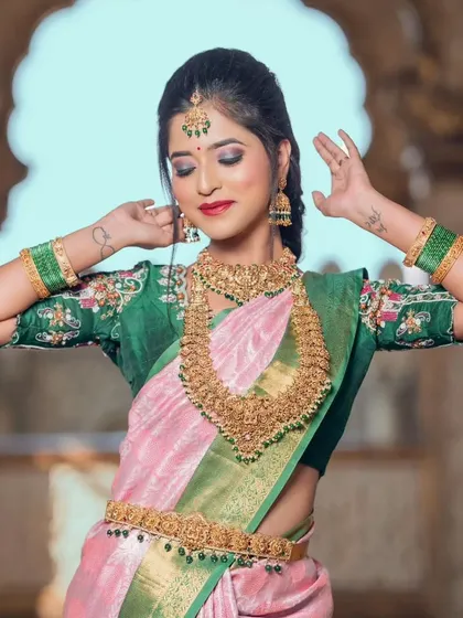 A playful pose from the bride, giving a great view of the layered necklaces and matching green bangles.