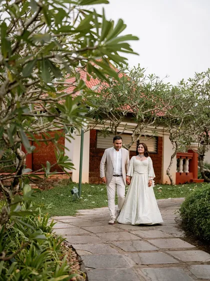 The couple sharing a moment on a pathway at the Caravela Beach Resort, hand in hand.