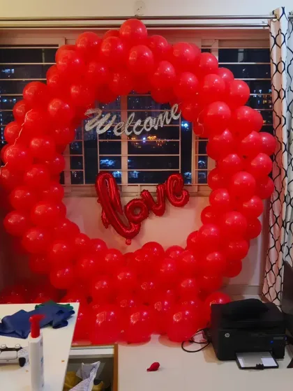 A romantic 'Welcome Home' decoration for a loved one. This all-red balloon ring with a 'Welcome' and 'Love' sign creates a passionate and heartfelt greeting.