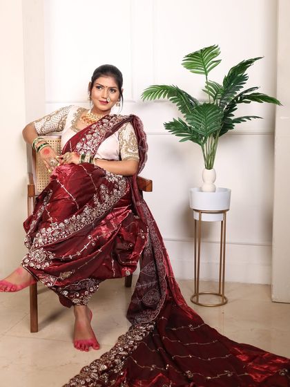 The full view of the maroon velvet Nauvari shows its beautiful drape and long trail, offering a regal and elegant silhouette.