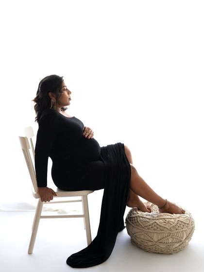 A seated pose that is both regal and relaxed. The long black gown drapes beautifully, creating a portrait that is full of grace and confidence.