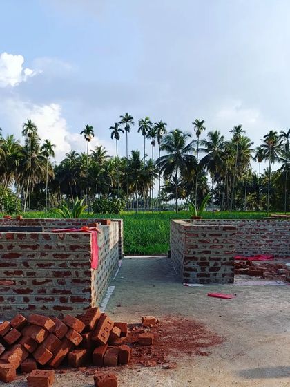 The foundation and initial walls of the yoga center, with the lush green landscape in the background. We start with the earth, and the building grows from there.