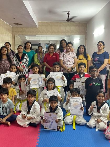 A group photo with students and their parents after the certificate distribution ceremony. The support of family is a huge part of a student's success.