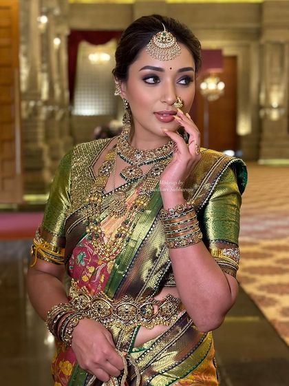 A glamorous pose highlighting the dramatic eye makeup and the traditional nose ring.