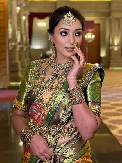 A glamorous pose highlighting the dramatic eye makeup and the traditional nose ring.