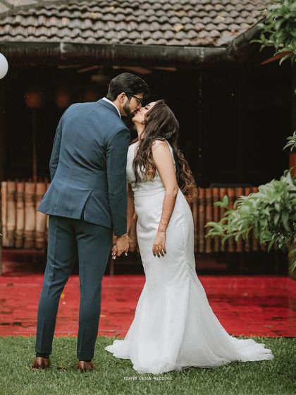 A sweet kiss shared between the bride and groom in a beautiful garden setting after their ceremony.