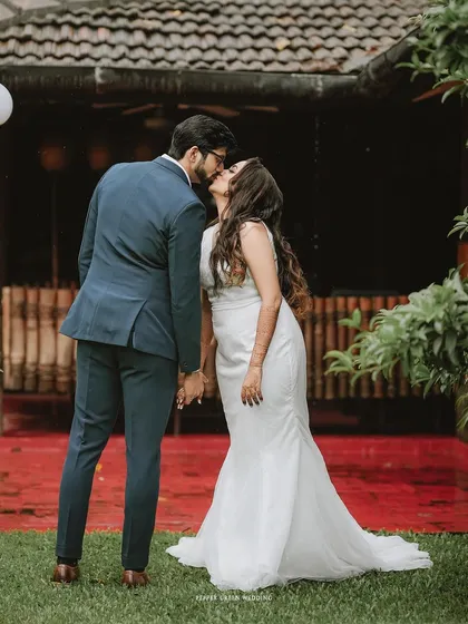 A sweet kiss shared between the bride and groom in a beautiful garden setting after their ceremony.
