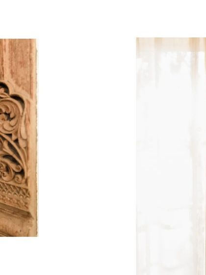 A close-up of a carved wooden element next to an exposed brick wall. The contrast between the refined craftsmanship of the wood and the rustic texture of the brick is something we love to explore.