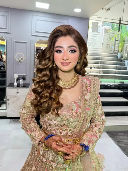 A solo shot of the beautiful bride-to-be. Her makeup is soft and glowing, and her hair is styled in glamorous waves.