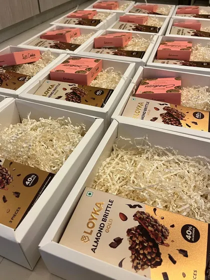 The initial stages of packing our budget-friendly Diwali boxes, showing the neat arrangement of gourmet chocolates and cookies before the final touches are added.