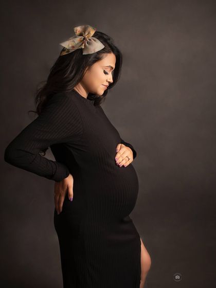 A beautiful black and white solo portrait against a dark studio background. The side profile and gentle lighting create a classic, elegant look.
