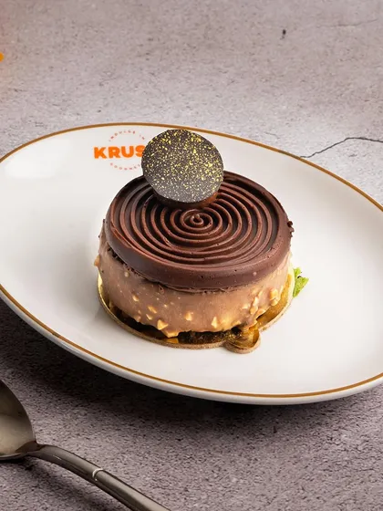 A beautifully crafted chocolate pastry with a spiral top and a crunchy base. I love experimenting with textures and shapes to create new and exciting desserts.