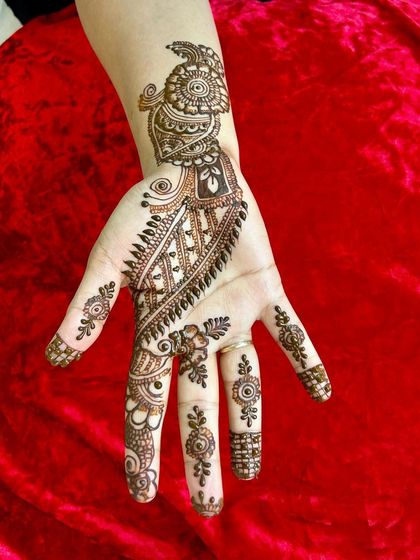 A classic Arabic-style vine design on the palm. The pattern flows diagonally from the index finger to the wrist, which is a hallmark of this elegant style.