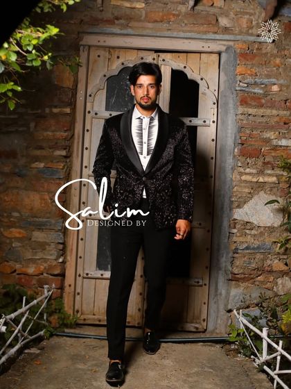 A model wearing a black velvet tuxedo with a subtle all-over pattern. This piece demonstrates how texture can be just as impactful as sparkle.
