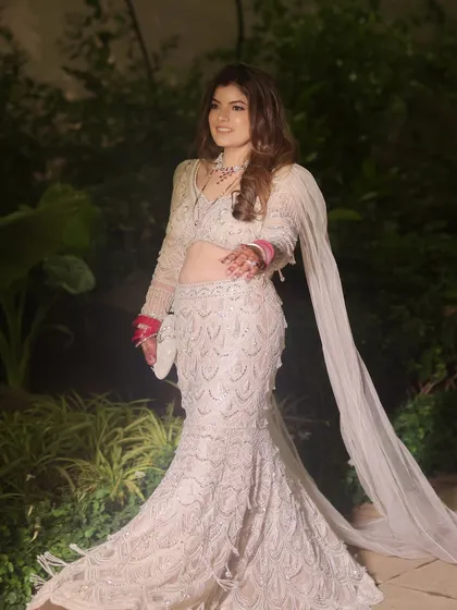 A full view of this stunning reception look. The bride is wearing a beautiful mermaid-style lehenga, and the makeup is kept glamorous yet elegant to match.
