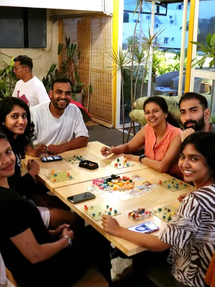 A group of friends enjoying a game of 'Project L' on the terrace. The mix of indoor and outdoor seating means you can always find your perfect gaming spot.