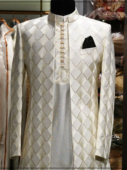 An elegant off-white Indo-Western sherwani with a geometric pattern. The layered look with the kurta underneath adds depth and sophistication.