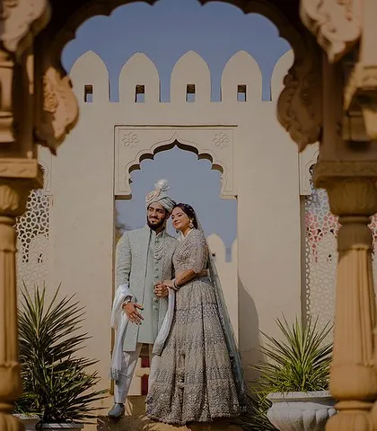 Framed between two pillars, this shot of Yash and Priyanshi offers a beautiful perspective of the couple against a backdrop of classic Indian architecture, creating a sense of depth and grandeur.