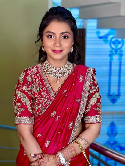 A beautiful engagement look for the sister of the bride in a vibrant red designer saree.