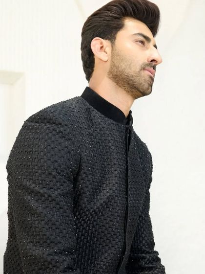 A profile view of the black Jodhpuri suit, highlighting the high collar and tailored fit. This is a garment that commands attention through its understated elegance.