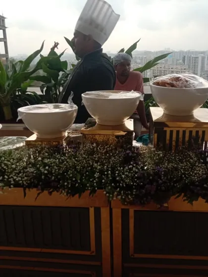 A view of our rooftop live counter setup, complete with elegant floral arrangements. Our team ensures a professional and beautiful presentation, no matter the location.