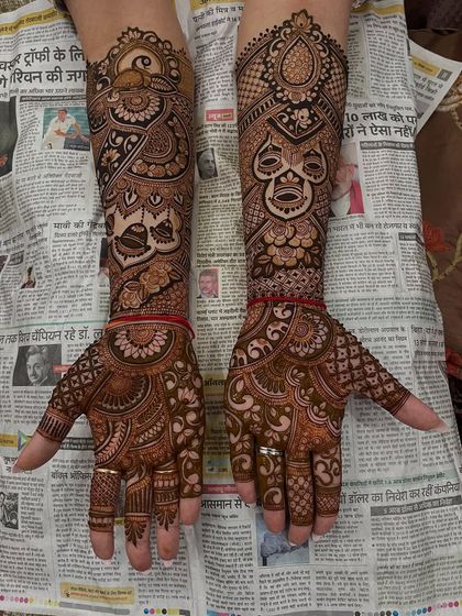 A full view of a complex bridal design, featuring masks, peacocks, and other traditional elements.