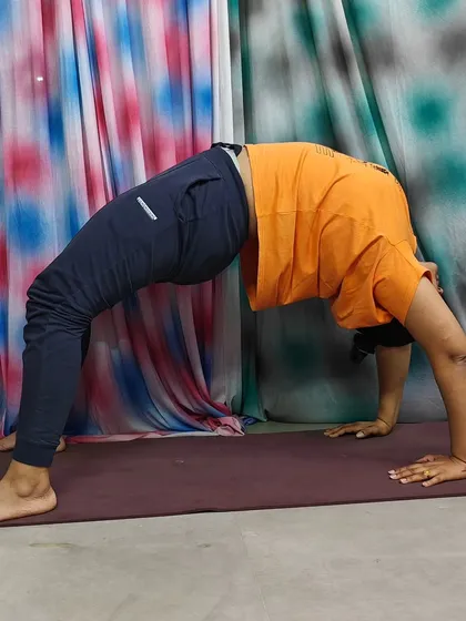 Performing Chakrasana (Wheel Pose), a powerful backbend that opens up the chest and strengthens the entire body. This asana is a beautiful expression of energy and flexibility.