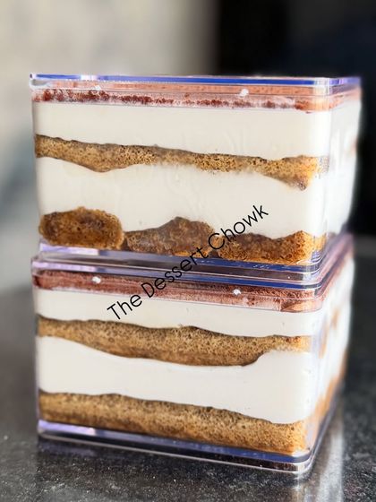 A side view of my Tiramisu tubs, stacked to show the neat, delicious layers of cream and coffee-soaked biscuits.