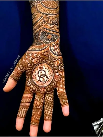 I love creating custom designs that tell your story. This engagement henna features the couple's initials, 'A' and 'Q', inside a central mandala with interlocking rings, symbolizing their union.
