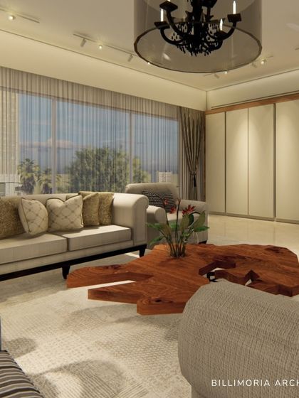 A closer view of the living area, showing the comfortable, deep-seated sofas and the unique live-edge coffee table that acts as a natural, sculptural centerpiece. Large windows provide ample light and a connection to the outdoors.