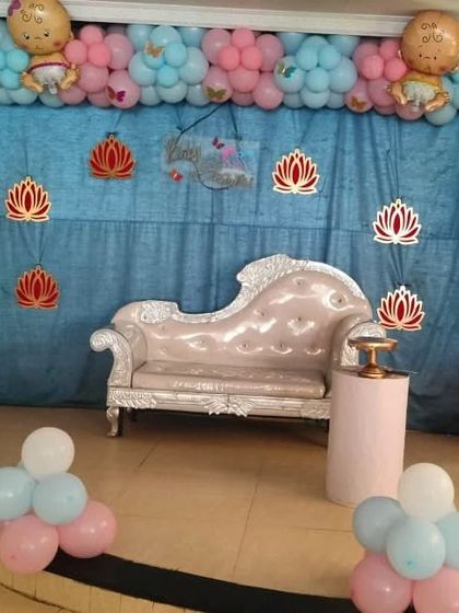 A complete balloon arch in pink and blue for a gender-neutral baby shower theme, complete with cute baby-shaped foil balloons.