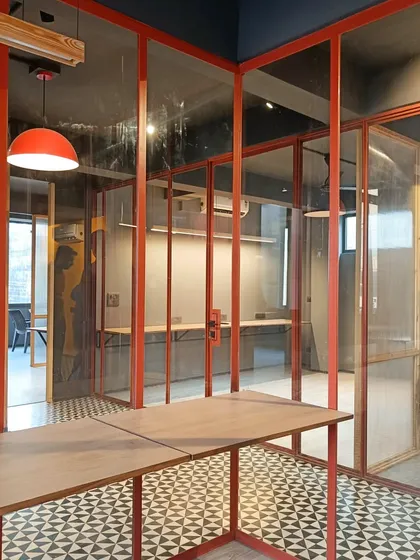 This view shows how the transparent and fluted glass partitions in the New Delhi office create layers of visibility and privacy, maintaining an open feel while delineating functional zones.