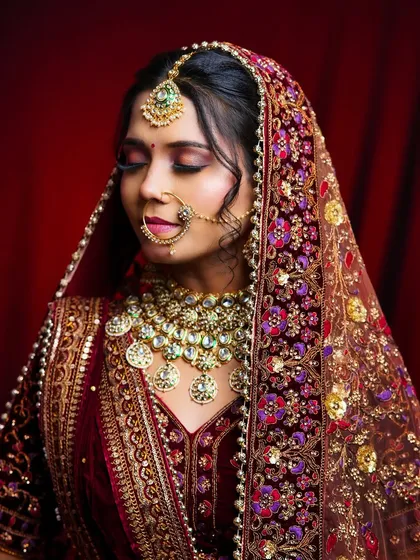 The bride is draped in a heavily embroidered dupatta, and the makeup by our student stands out with its rich colors and flawless application.