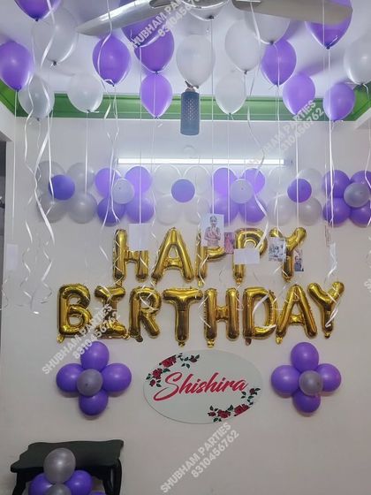 A purple and white themed home birthday decoration with a personalized nameplate.