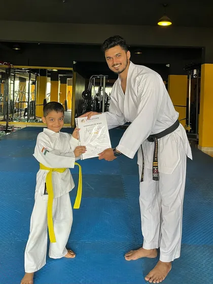 This yellow belt student is excited to receive his certificate and continue his karate training.
