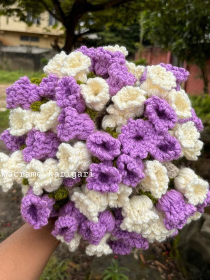 A top-down view of the crochet flower blanket bouquet. The purple and white flowers are handcrafted and make a stunning visual impression.