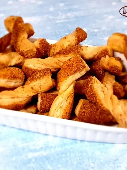 A perfect savory treat, our Cheese Straws are light, crispy, and full of cheesy flavor. This image shows a bowl full of these twisted puff pastry sticks, baked to a perfect golden brown. They are incredibly addictive and great for sharing.