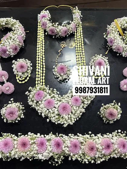 Here is a complete baby shower jewellery set, ready to be worn. This design features a beautiful combination of baby's breath and soft pink flowers, including a necklace, maang tikka, earrings, hand pieces, and a matching kamarbandh.