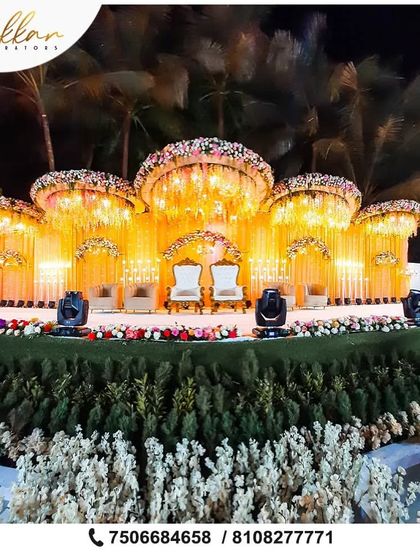 A larger-than-life outdoor reception stage with multiple floral canopies. This grand design is perfect for making a statement at a large-scale wedding.