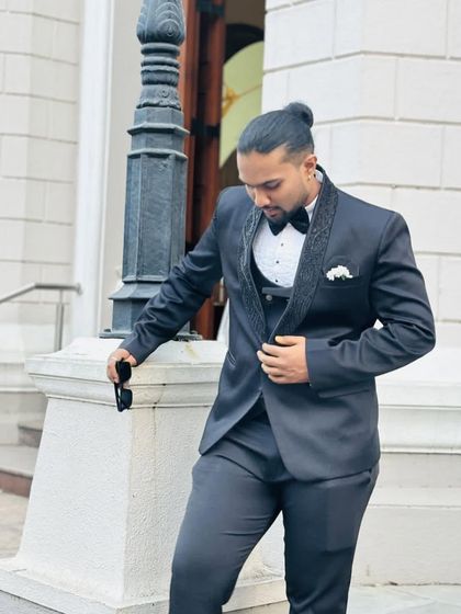 A modern and dapper look. This client looks effortlessly cool in a black tuxedo, complete with a stylish man bun and sunglasses.