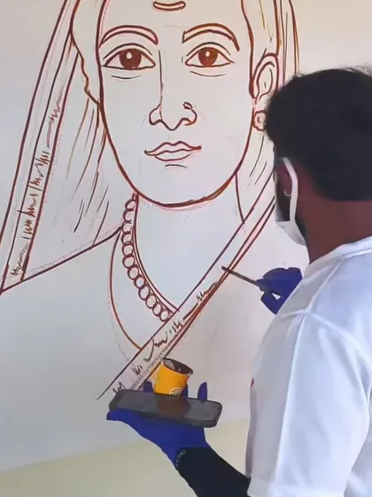 The initial line work for a portrait of Savitribai Phule, a pioneer of women's education in India, being painted on a school wall.