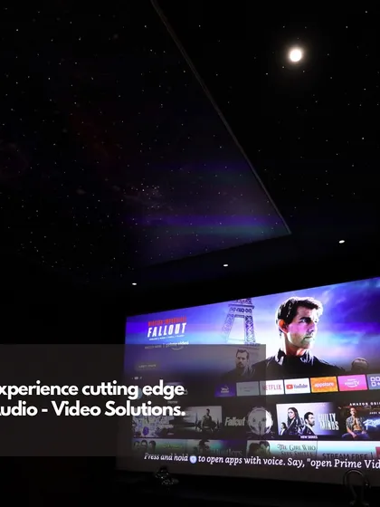 Our cutting-edge audio-video solutions bring the cinema home. This image captures the large, bright projection screen displaying a popular streaming interface, ready for an evening of entertainment under a custom starlight ceiling.