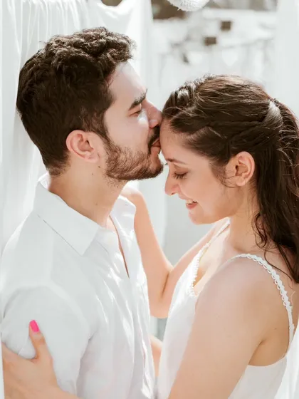 A sweet and intimate forehead kiss captured in a moment of bright, natural light. This simple and beautiful portrait highlights the tender connection between the couple during their Mumbai shoot.