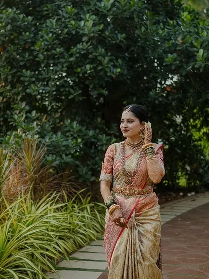 My beautiful client-turned-family, Chethana, looks timeless in this white and pink Kanchipuram saree. I designed a heavily handcrafted bridal blouse with intricate zardozi work to complement the saree's elegance for her special day.