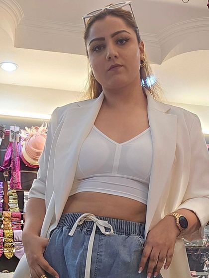 The full power look, pairing a white blazer and crop top with denim joggers. The gold watch and statement earrings from our collection tie it all together for that effortlessly cool vibe.