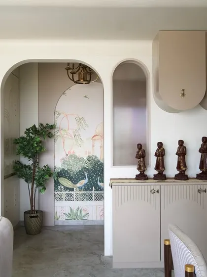 Arches frame this beautiful corner in the 'Vrindavan' home, where a peacock mural adds a touch of traditional artistry. It's a celebration of heritage within a modern, neutral setting.