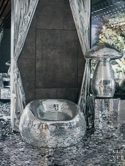 Guests at 'The Melting Disco Ball' were greeted by a shimmering path of silver confetti. The space was filled with mirrored furniture, reflective curtains, and disco-inspired sculptures like this mushroom, creating a captivating illusion of infinite, glittering space.