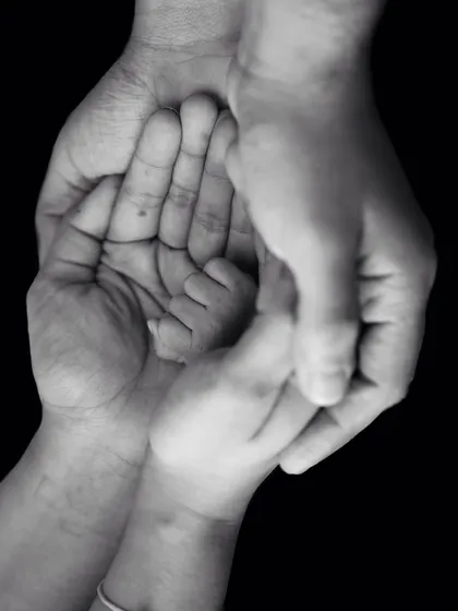 Little things that aren't really little. A beautiful black and white photo showing the hands of the whole family coming together around the baby's.