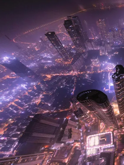 This warped aerial perspective gives a sense of falling into the city's glowing grid. It's an experimental drone shot that plays with perception and scale.