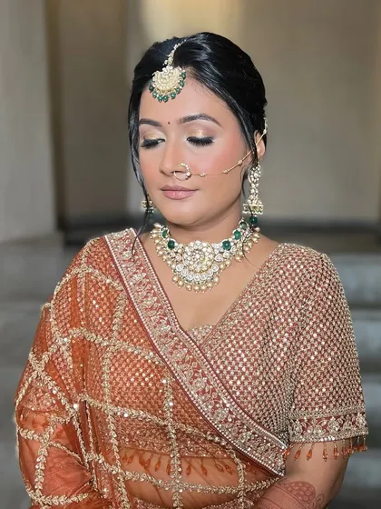 A close-up of the bridal makeup, showing the soft gold shimmer on the eyes and the flawless base that works beautifully with the bride's skin tone.